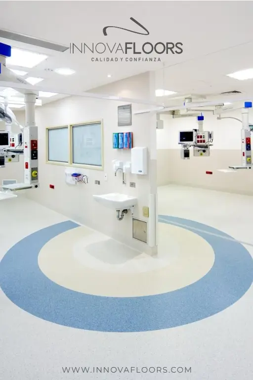 	Piso vinílico homogéneo clínico con círculo central en azul y beige, instalado en un quirófano moderno